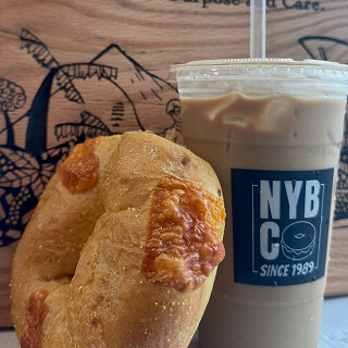 Bagel beside an NYBC iced coffee
